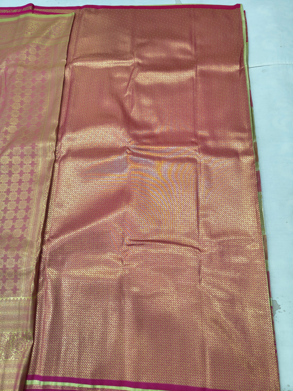 Silk saree fabric with gold and copper sheen, small woven motifs, pink trim