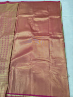 Silk saree fabric with gold and copper sheen, small woven motifs, pink trim