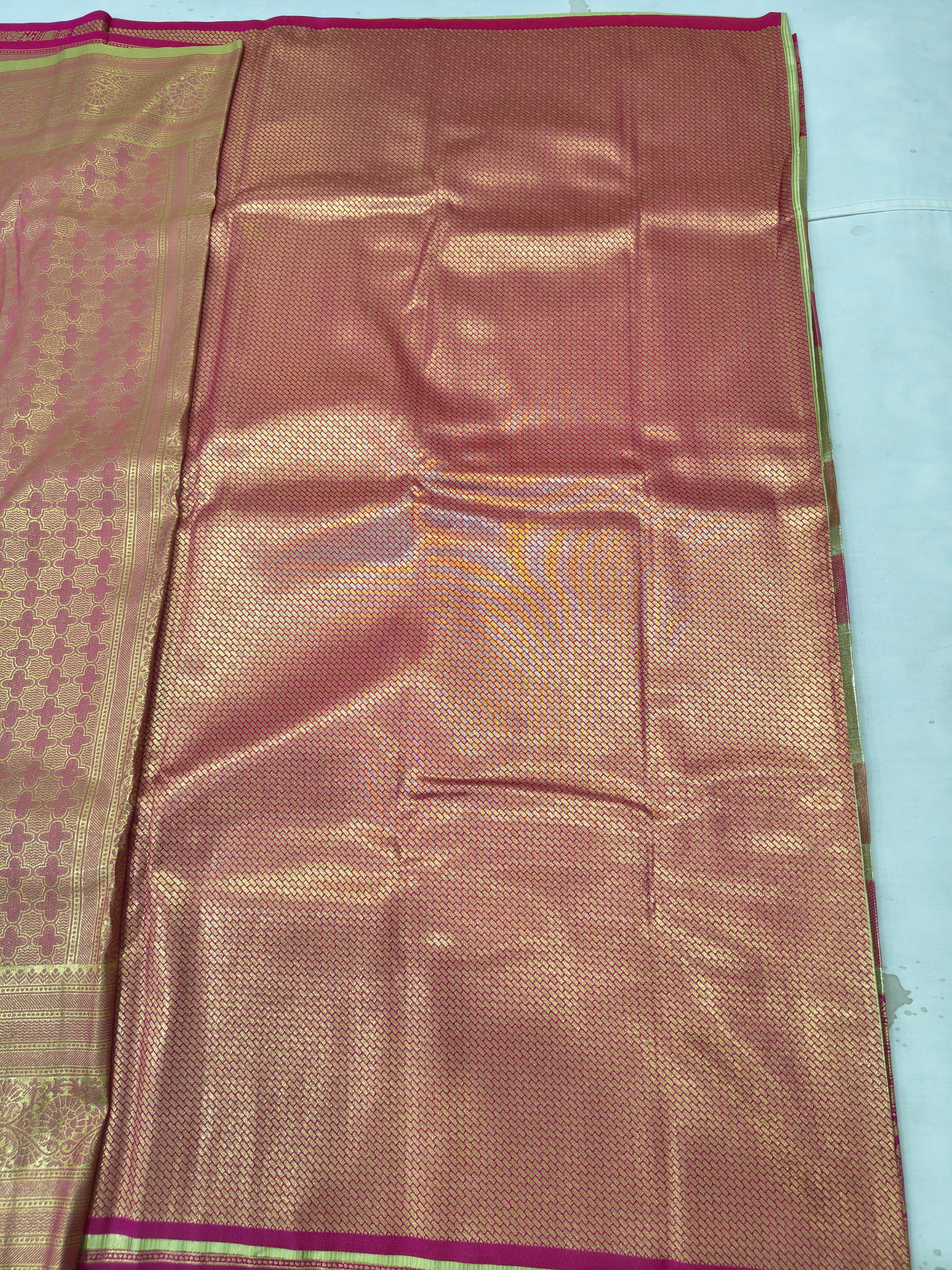 Silk saree fabric with gold and copper sheen, small woven motifs, pink trim