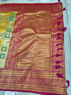 Banarasi silk saree close-up with gold sheen, pink border, and square woven motifs