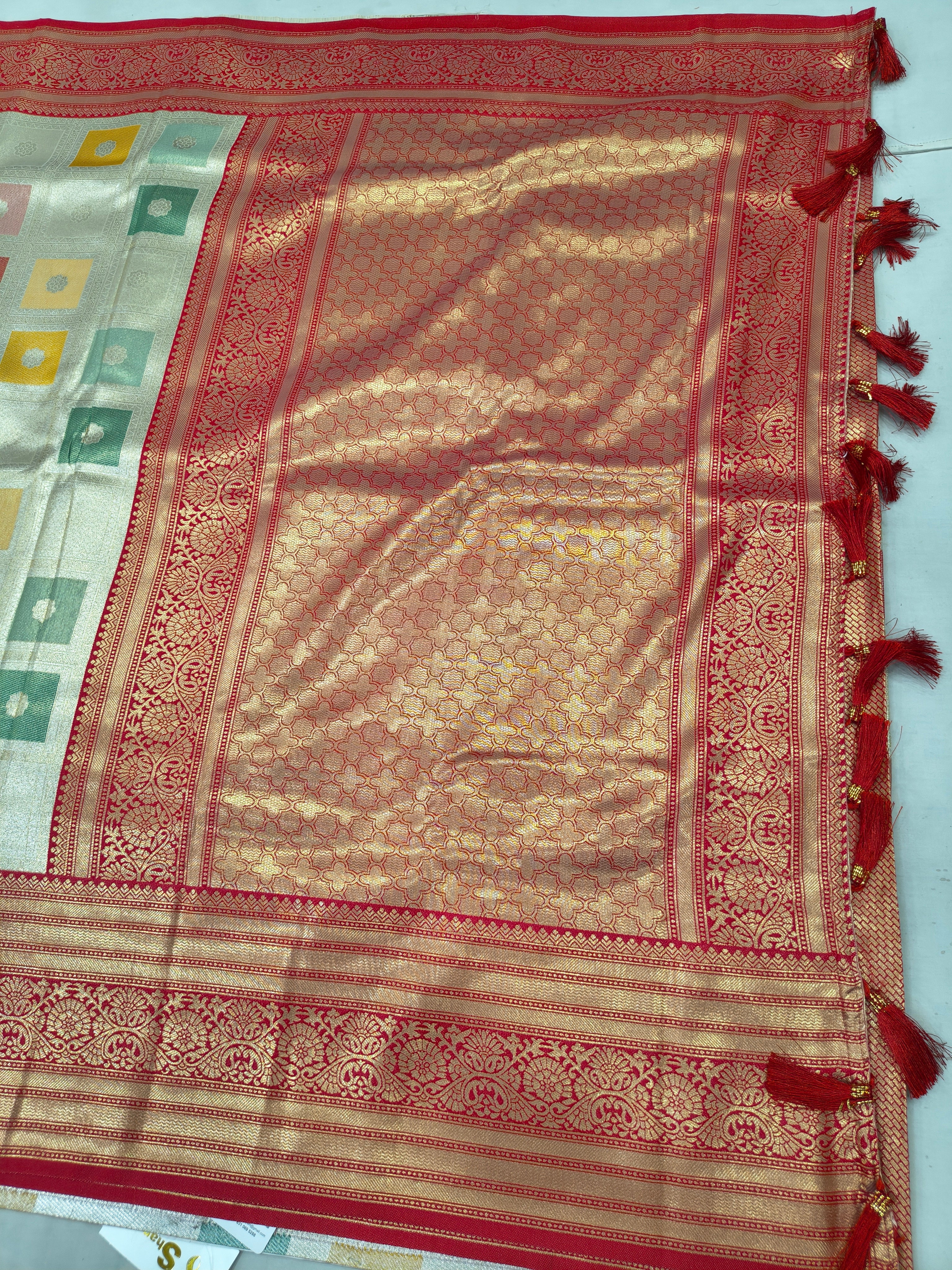 Gold and red Banarasi silk saree close-up with red ornate border and patterned body