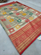 Gold and red Banarasi silk saree flat lay with geometric blocks and ornate red border