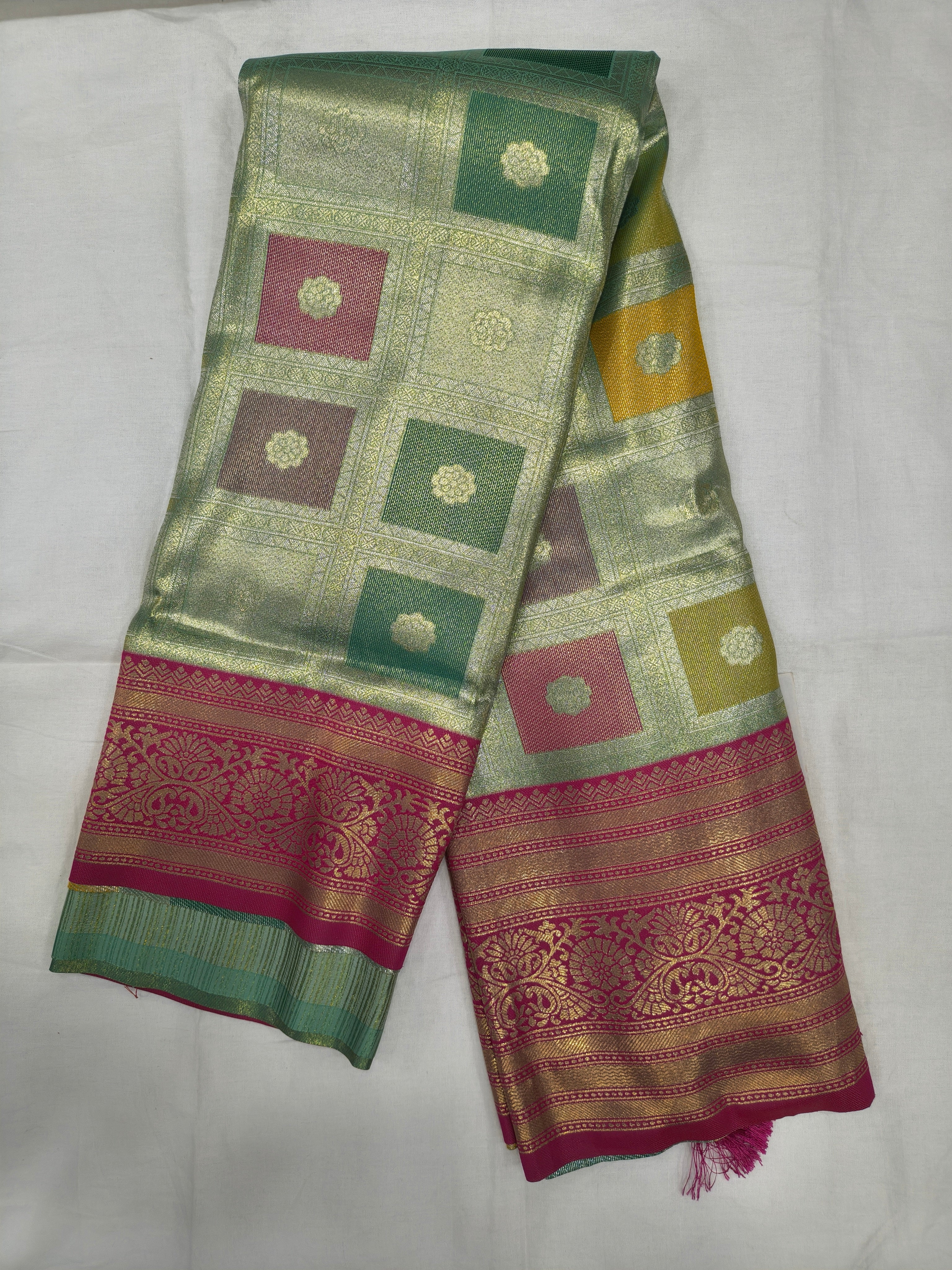 Pastel silk saree with green square motifs and magenta brocade border, tassels