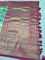 Pastel silk saree border detail with magenta trim and tassels, woven motifs