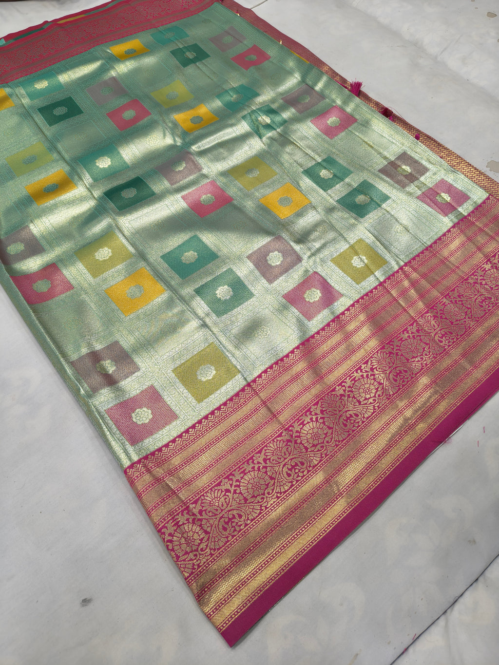 Pastel silk saree with teal and gold geometric motifs, pink border and pallu