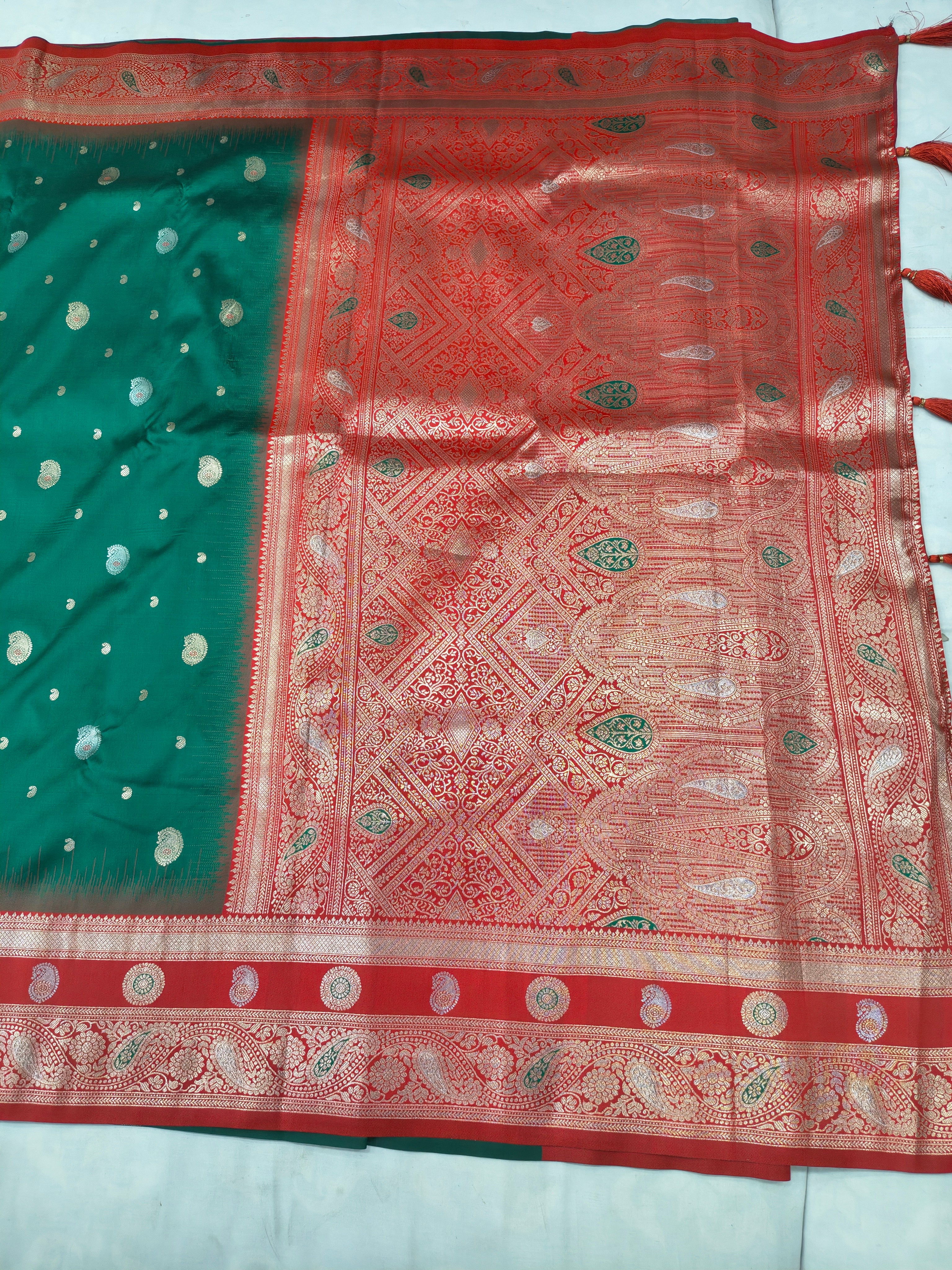 Banaras silk saree close-up: teal section with gold dots and red ornate central panel