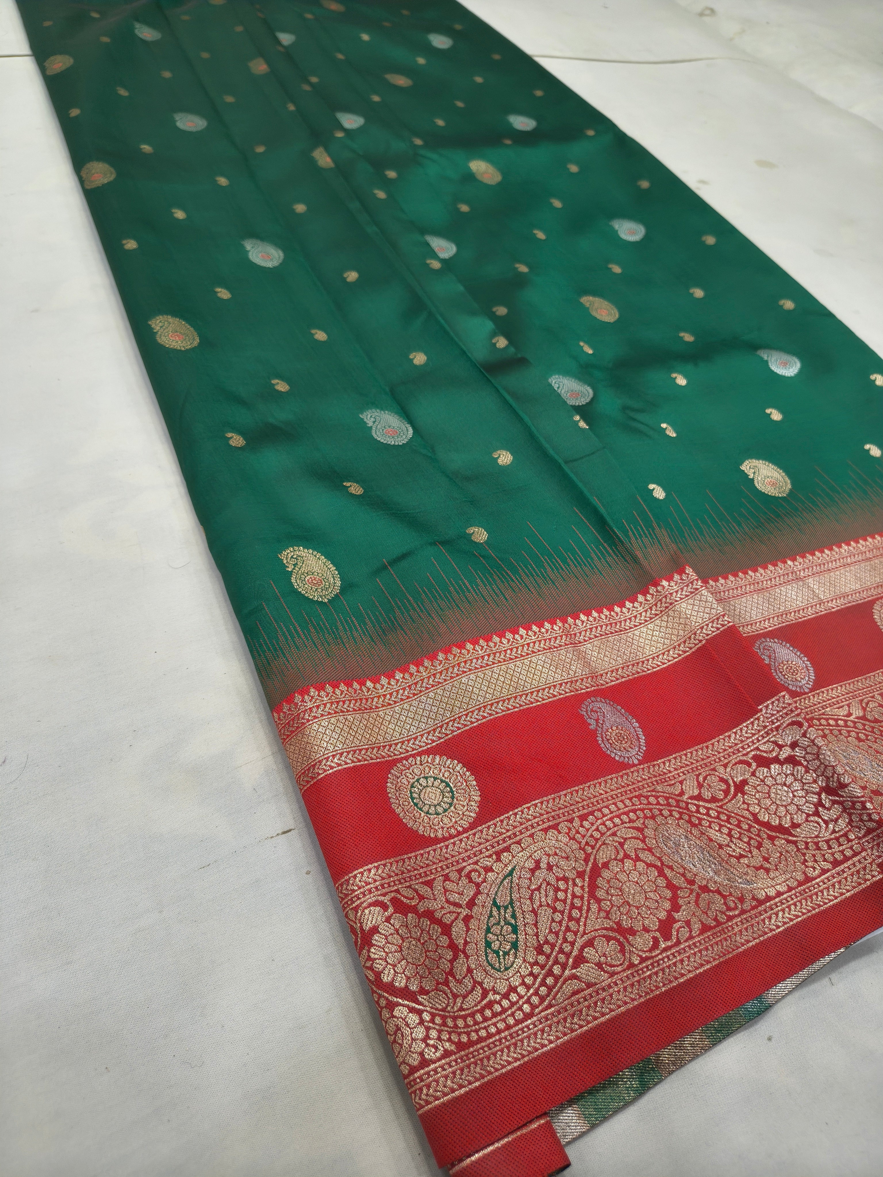 Teal green silk saree with scattered gold motifs and red border with paisley patterns