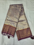 Silver and purple Banarasi silk saree with wide border and tassel fringe ends