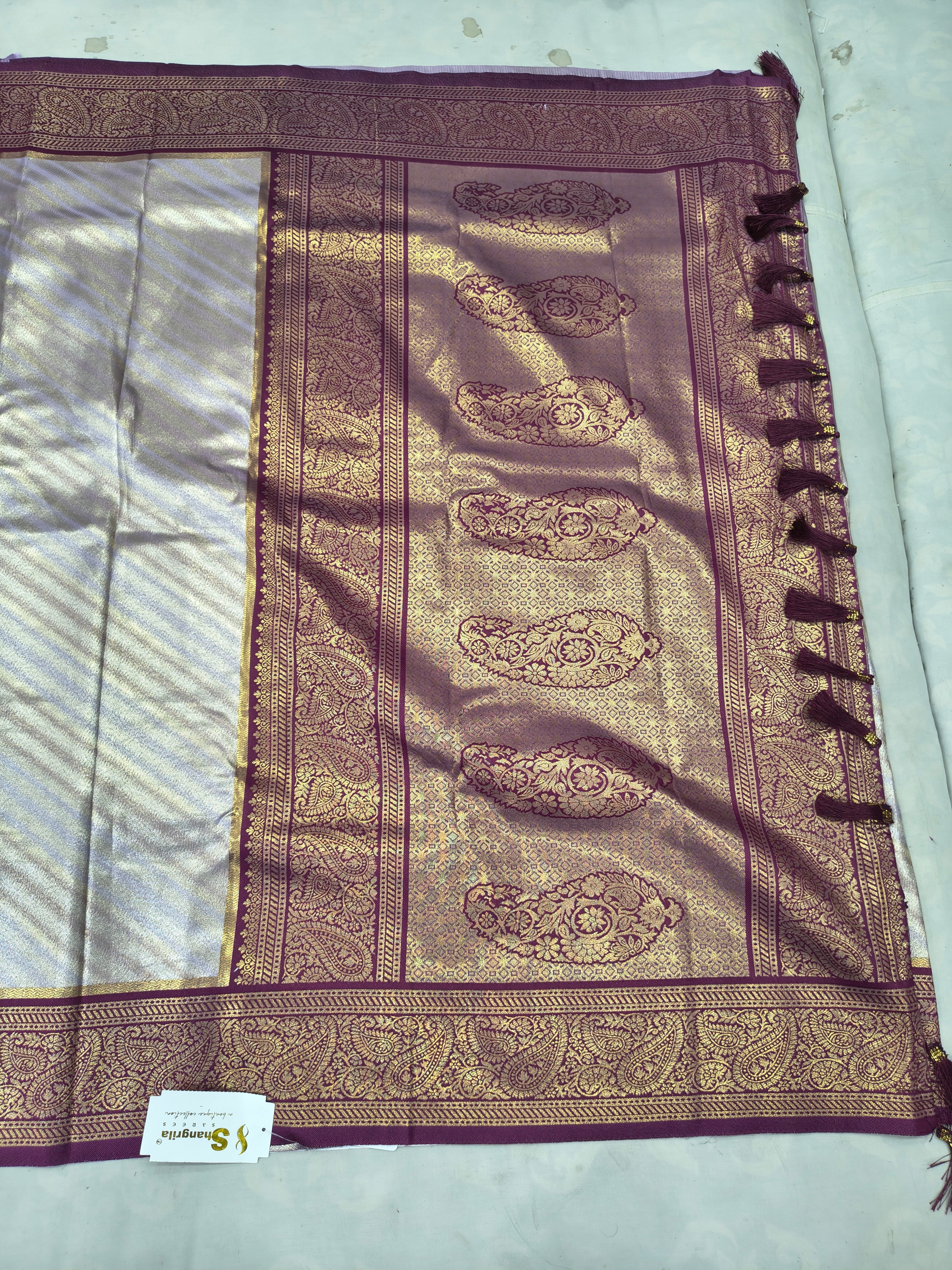 Silver and purple Banarasi silk saree border with paisley motifs and tassels