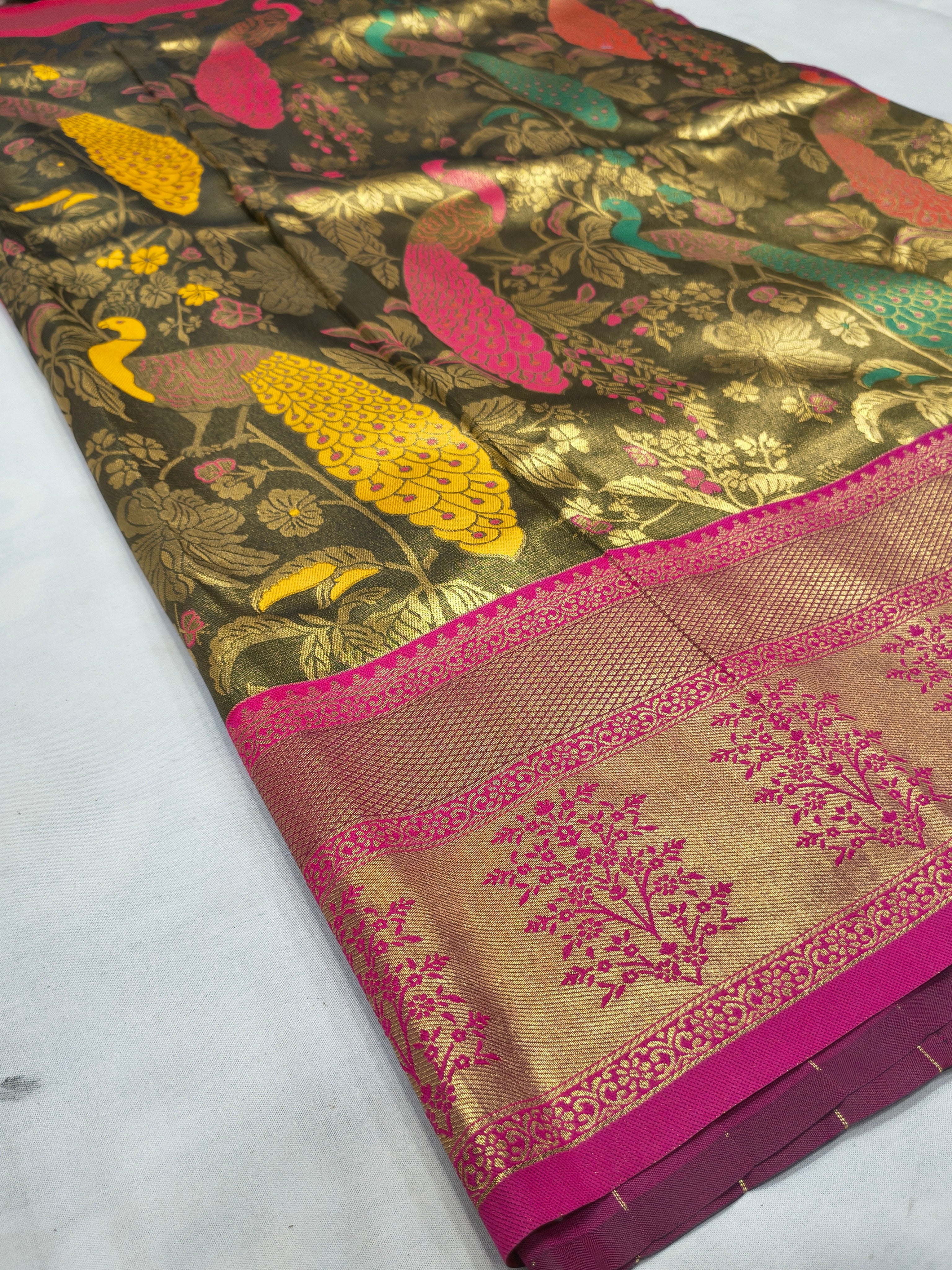 Olive-green silk saree with gold animal and floral motifs and pink-magenta border