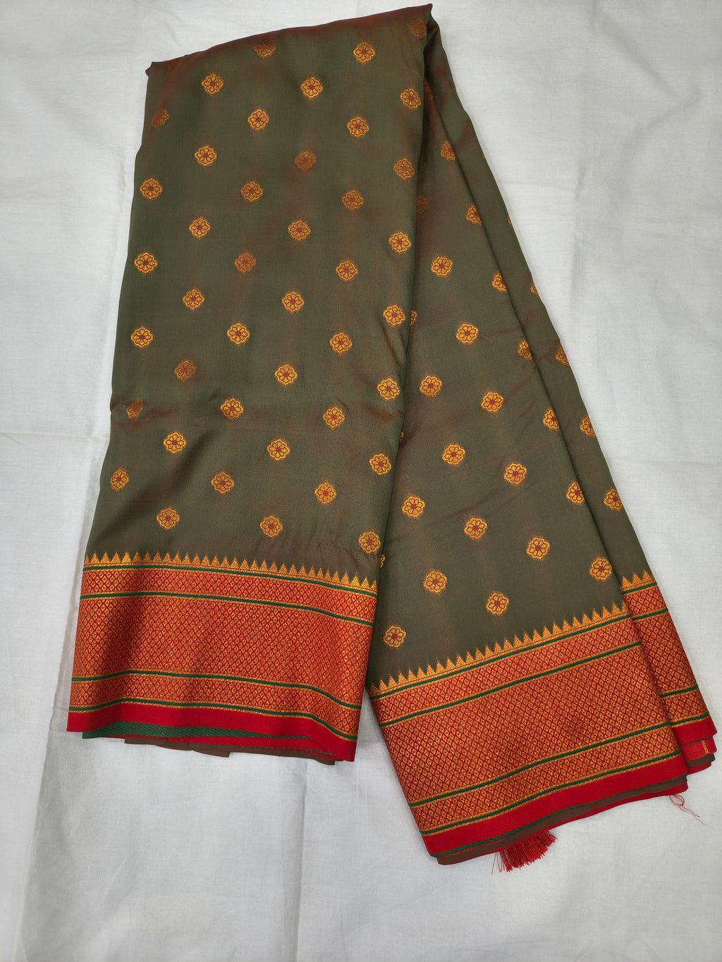Grey-green Banarasi-style silk saree with orange border and small golden motifs