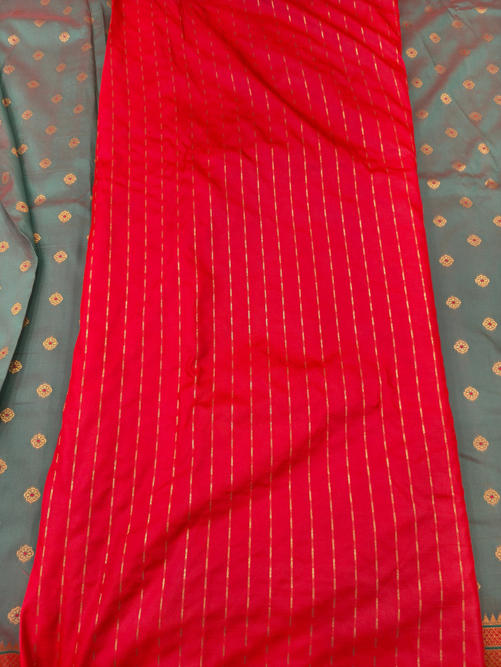 Red silk saree with fine vertical striped weave and smooth patterned drape
