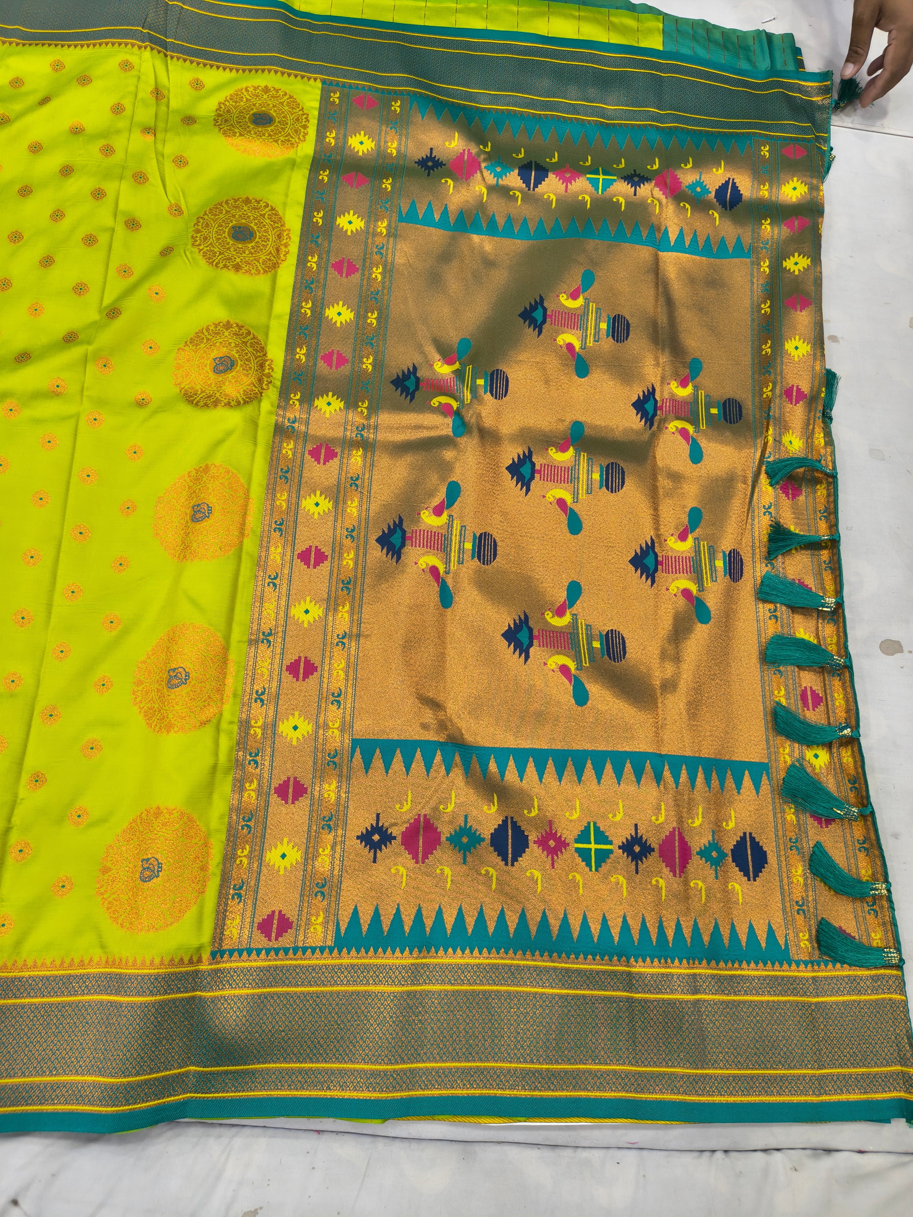 Neon yellow saree with geometric motifs and multicolor border, teal pallu