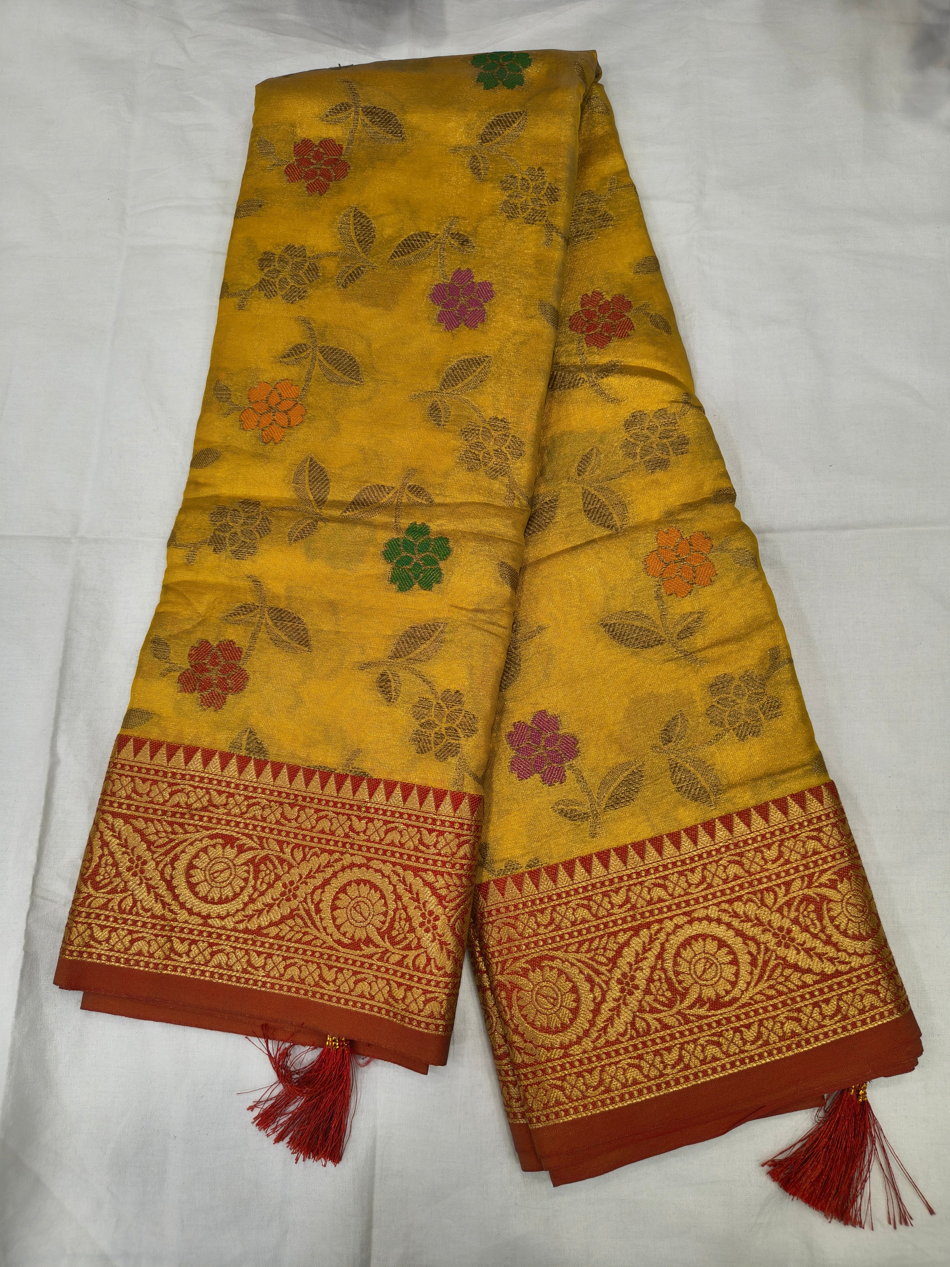 Mustard yellow silk saree with floral vine pattern and red border, unstitched blouse