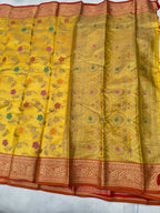 Mustard yellow silk saree with floral jaal motifs, wide red-gold border and tassels