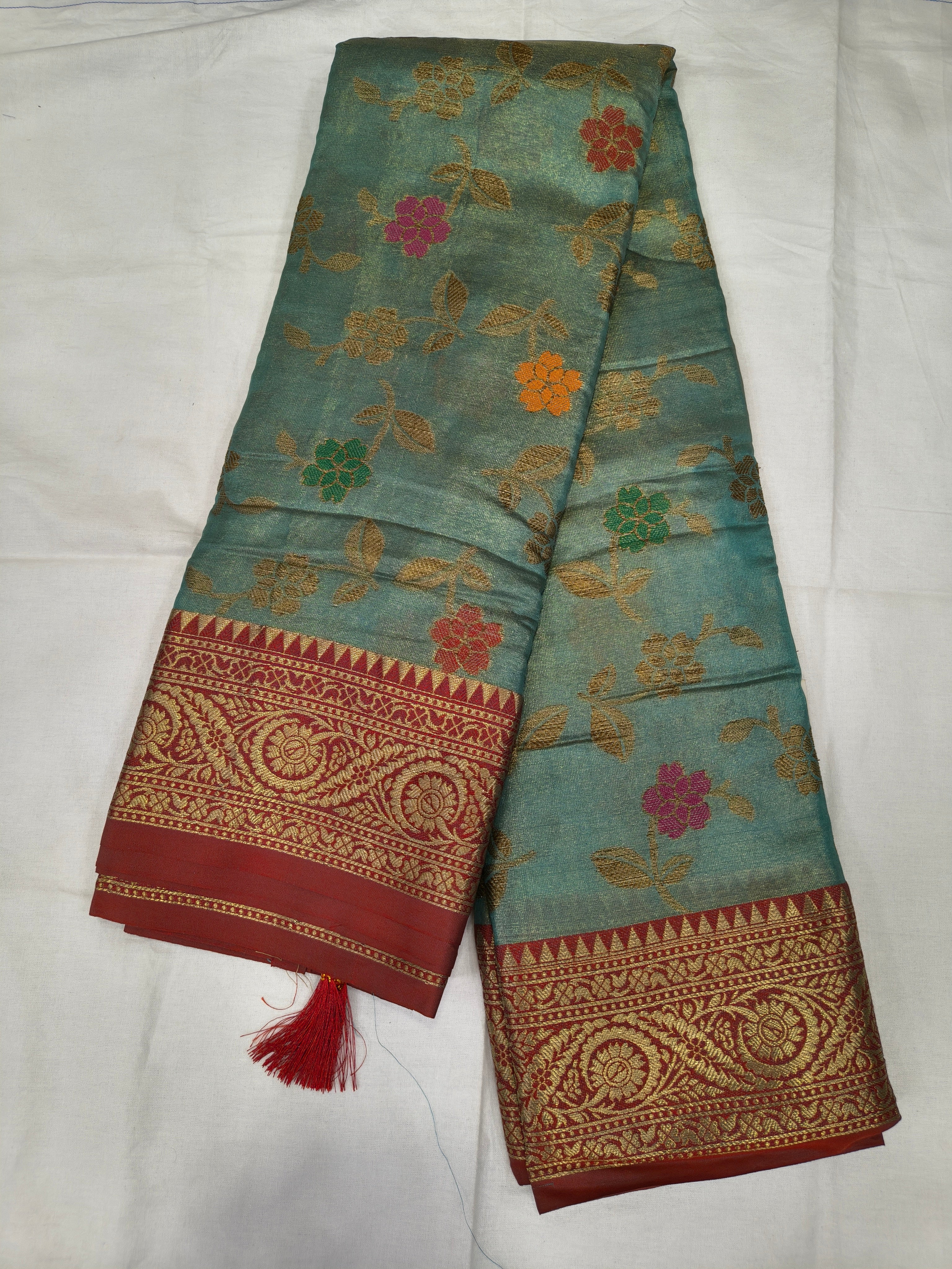 Teal sky-blue silk saree with red-gold Kanchipuram-style border and floral motifs