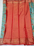 Red silk saree panel with repeating motifs and ornate gold border; teal edge visible