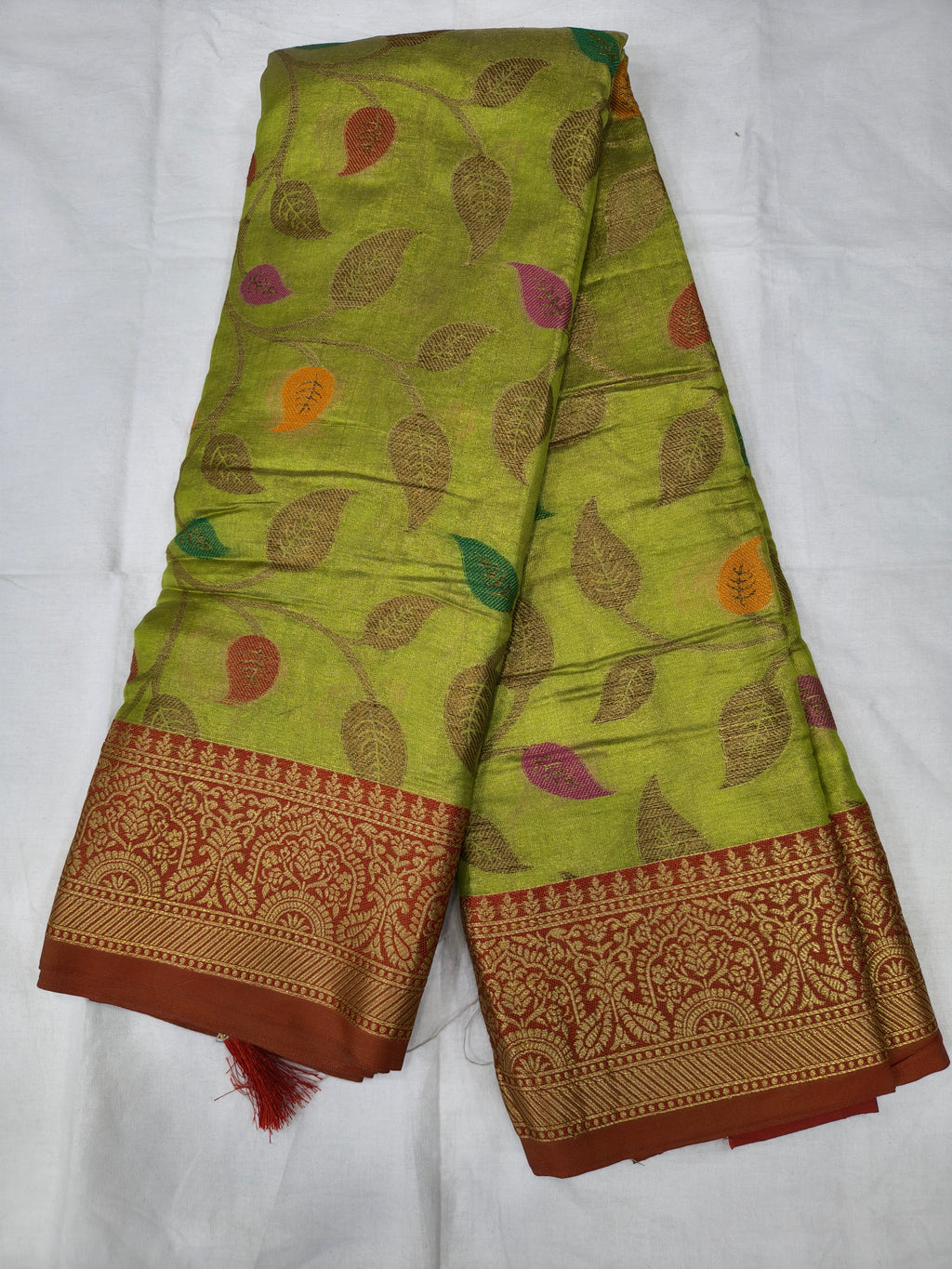 Light green silk saree with leaf motifs and maroon woven border