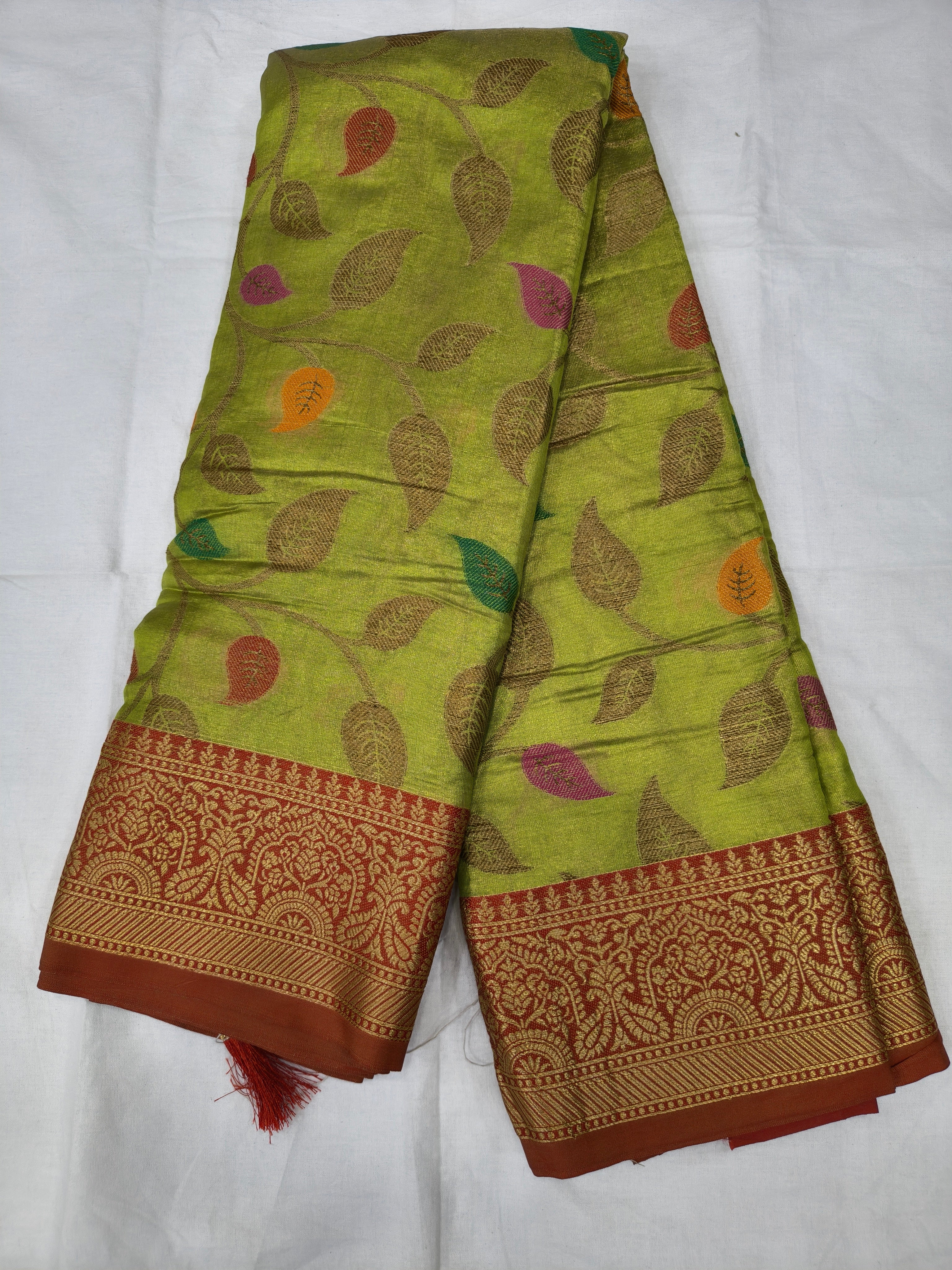 Light green silk saree with leaf motifs and maroon woven border