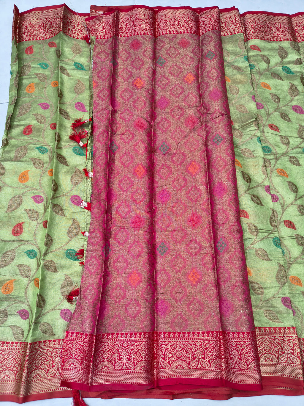 Green saree with leaf print sides and central maroon-pink patterned panel