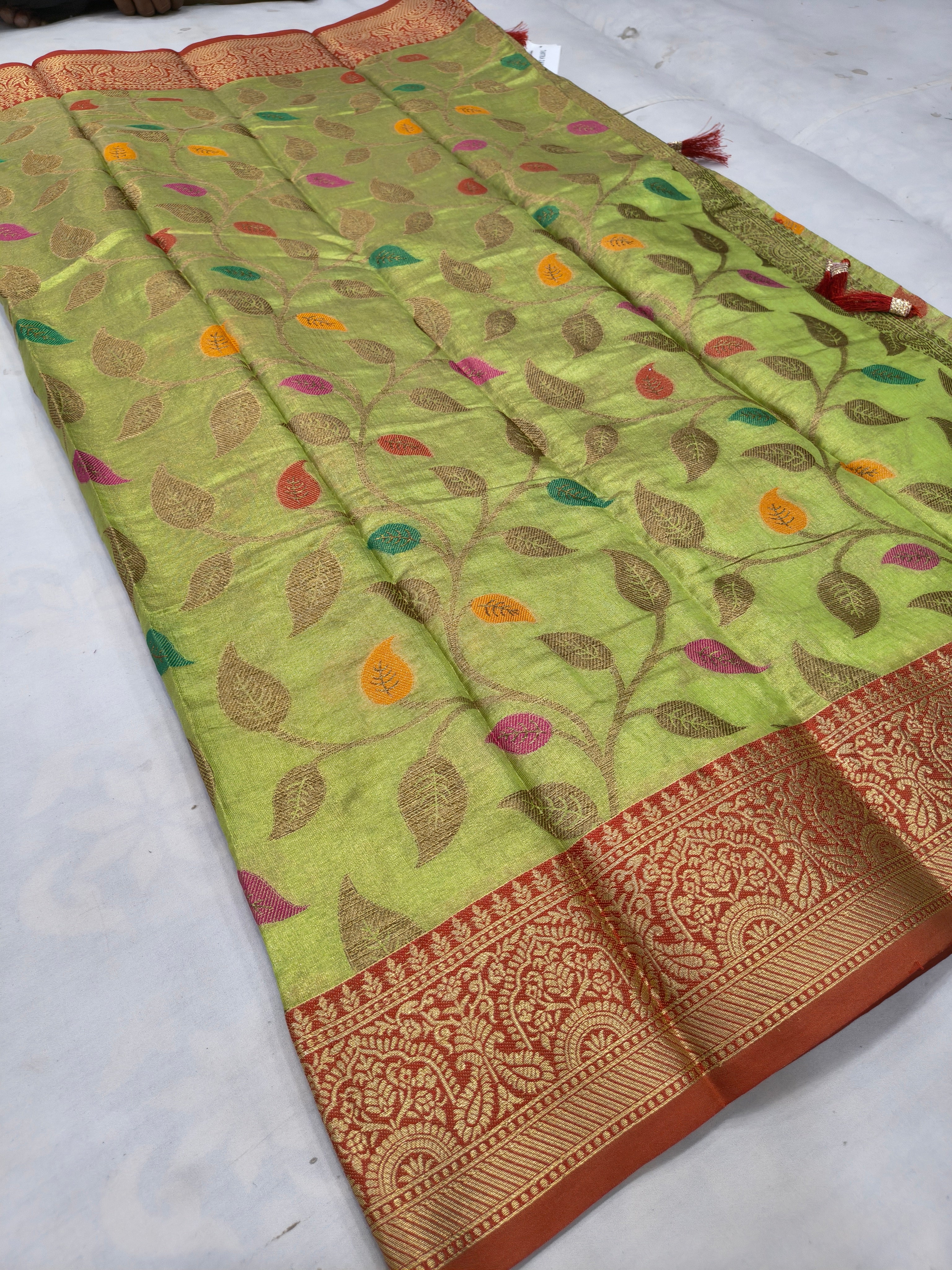 Light green saree with leaf motifs and ornate maroon border on one edge
