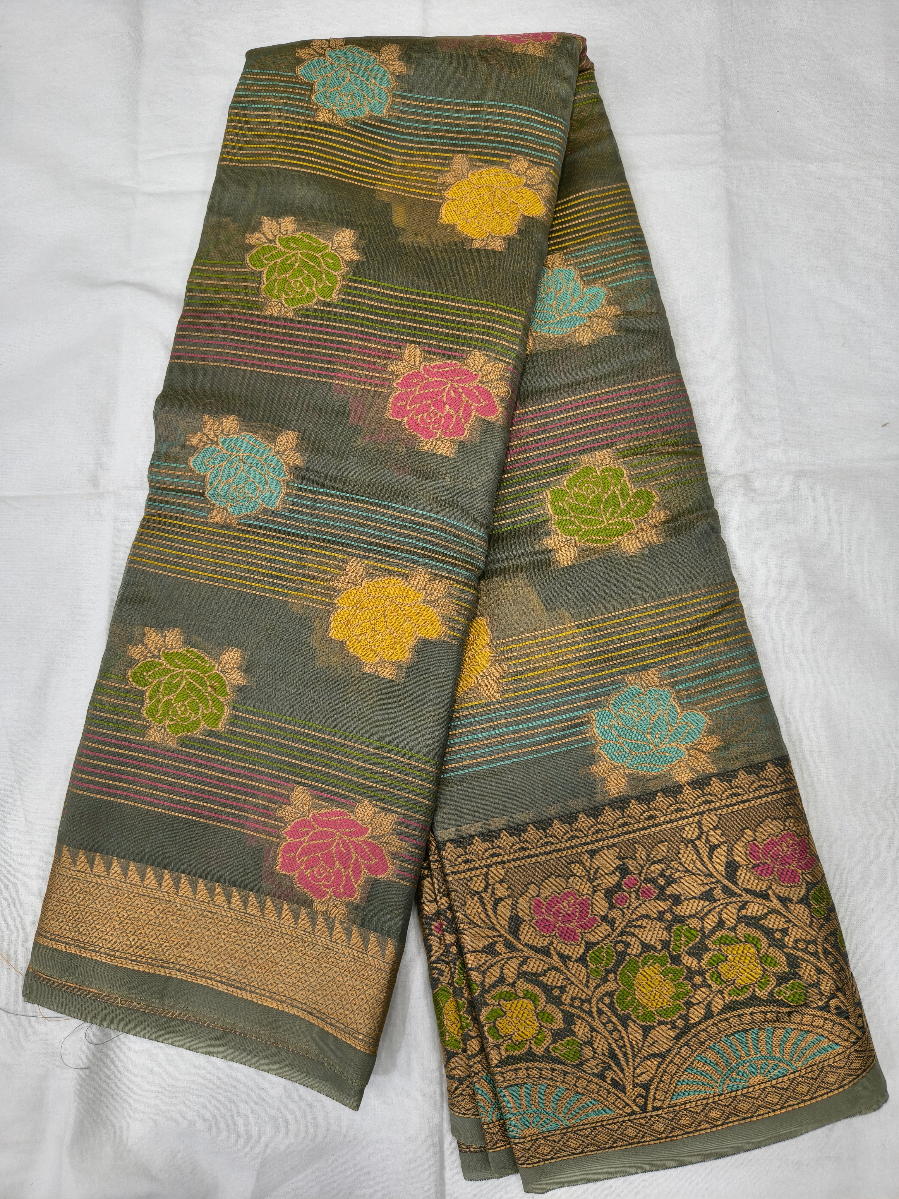 Dark grey silk saree folded, multicolor stripes and floral motifs with gold border