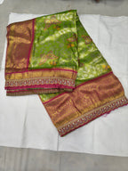 Light green and pink silk saree with ornate gold border and contrasting blouse panel