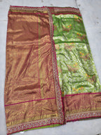 Green and maroon silk saree with woven gold border, pallu section and patterned texture