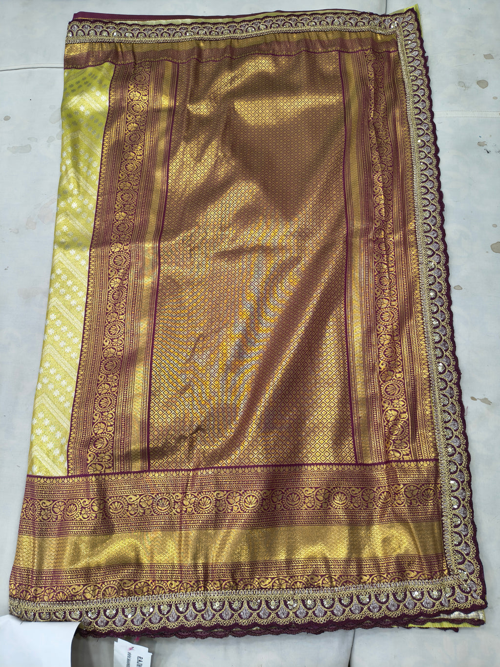 Banarasi silk saree fabric close-up, olive green with maroon border and motifs