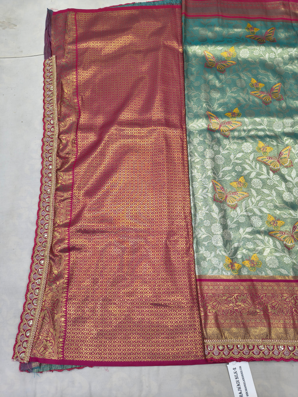 Two-tone saree fabric: maroon-pink center with teal-green side panel and ornate trim