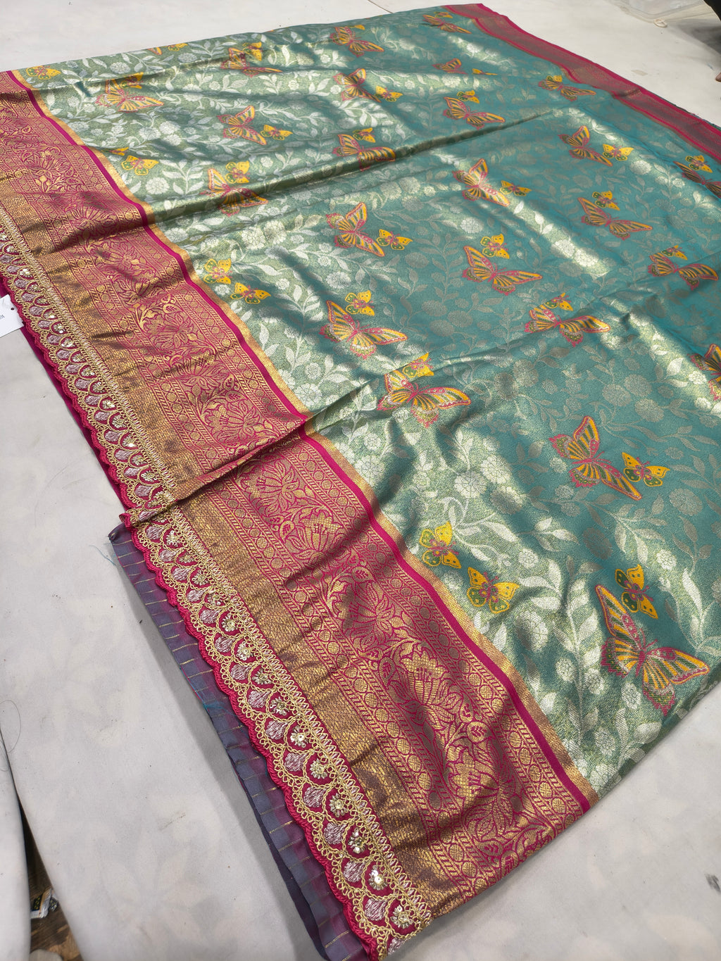 Teal-green Banarasi silk saree with pink border and scattered gold motif work