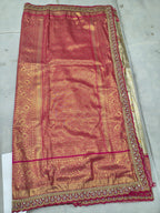 Pink Banarasi silk saree fabric with gold motifs and ornate hot-pink border, flat lay