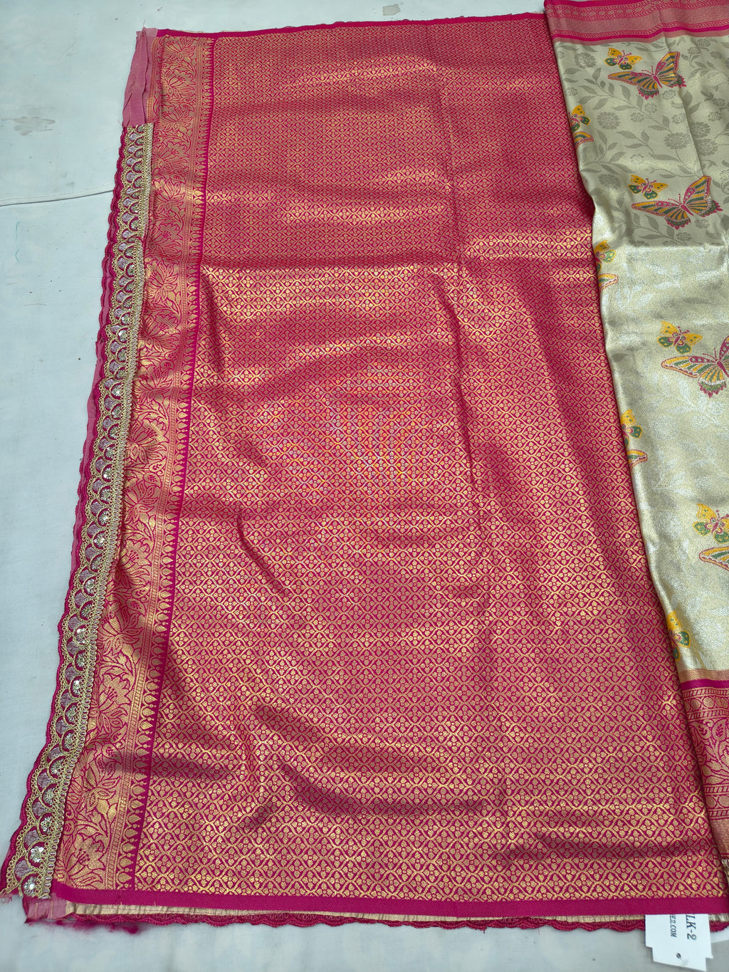 Unstitched pink Banarasi silk blouse fabric with decorative gold edge and patterned design