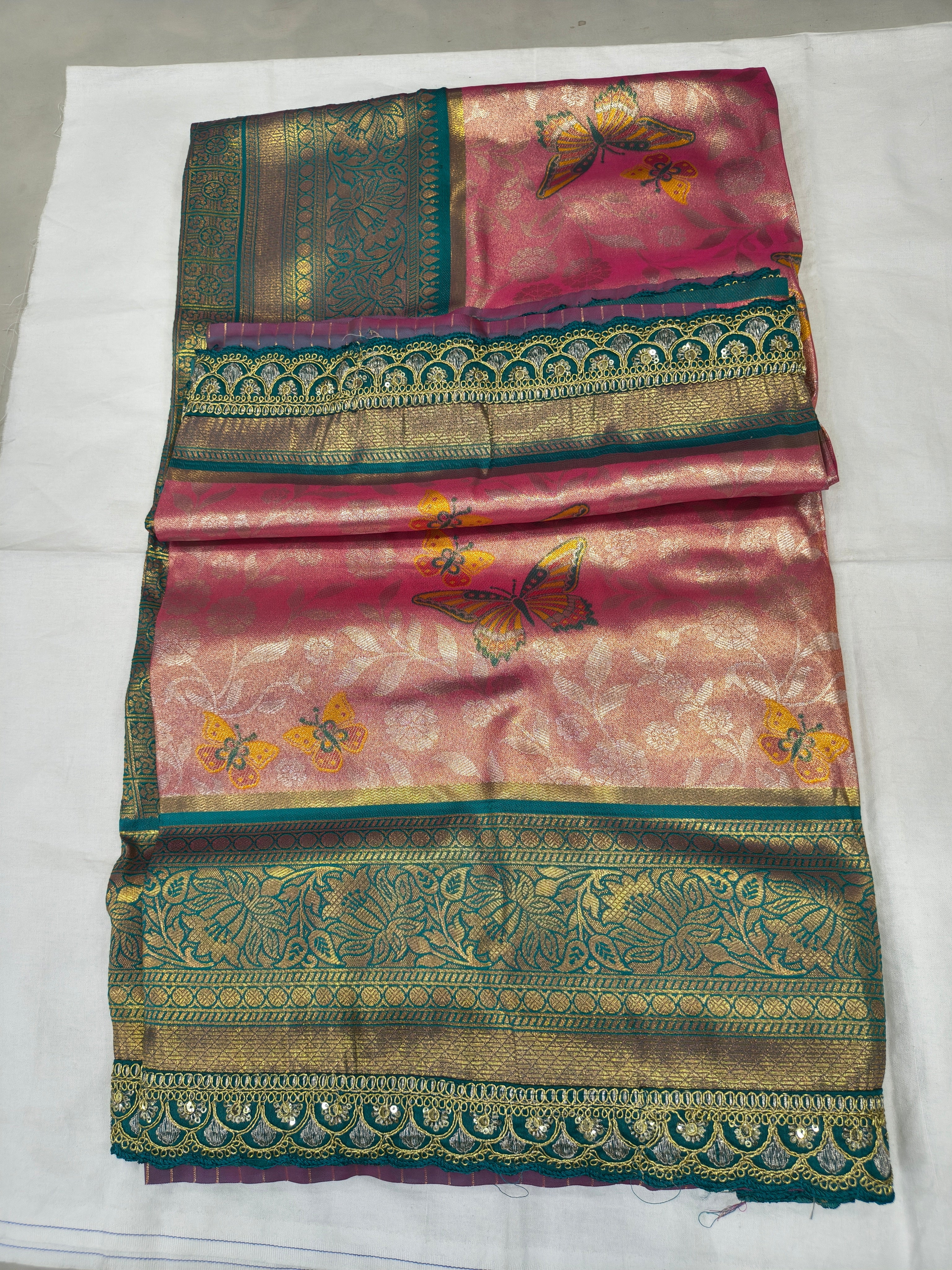 Folded pink and teal Banarasi silk saree with ornate gold border