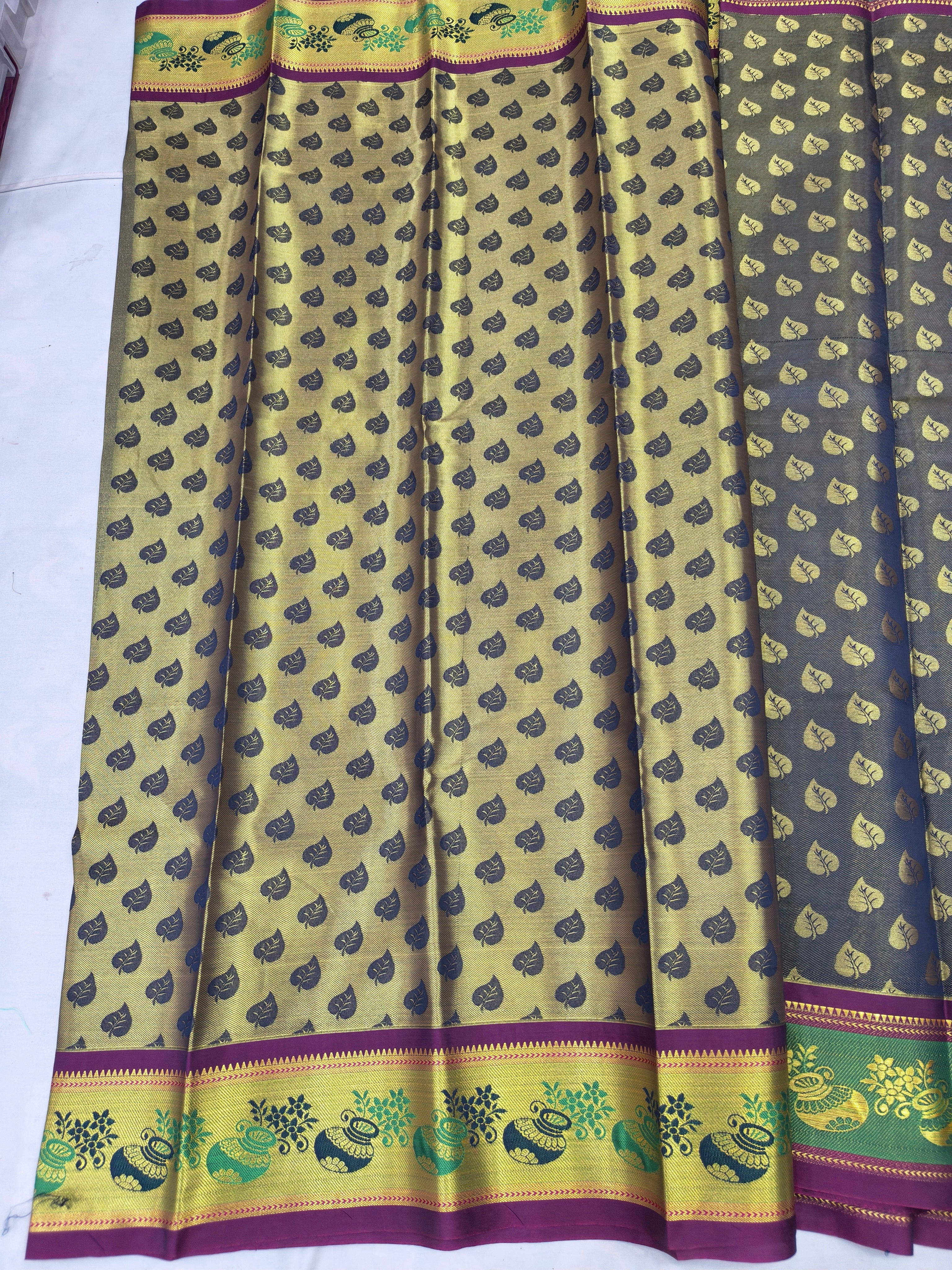 Beige saree with repeating peacock motifs, green pallu stripes, purple border