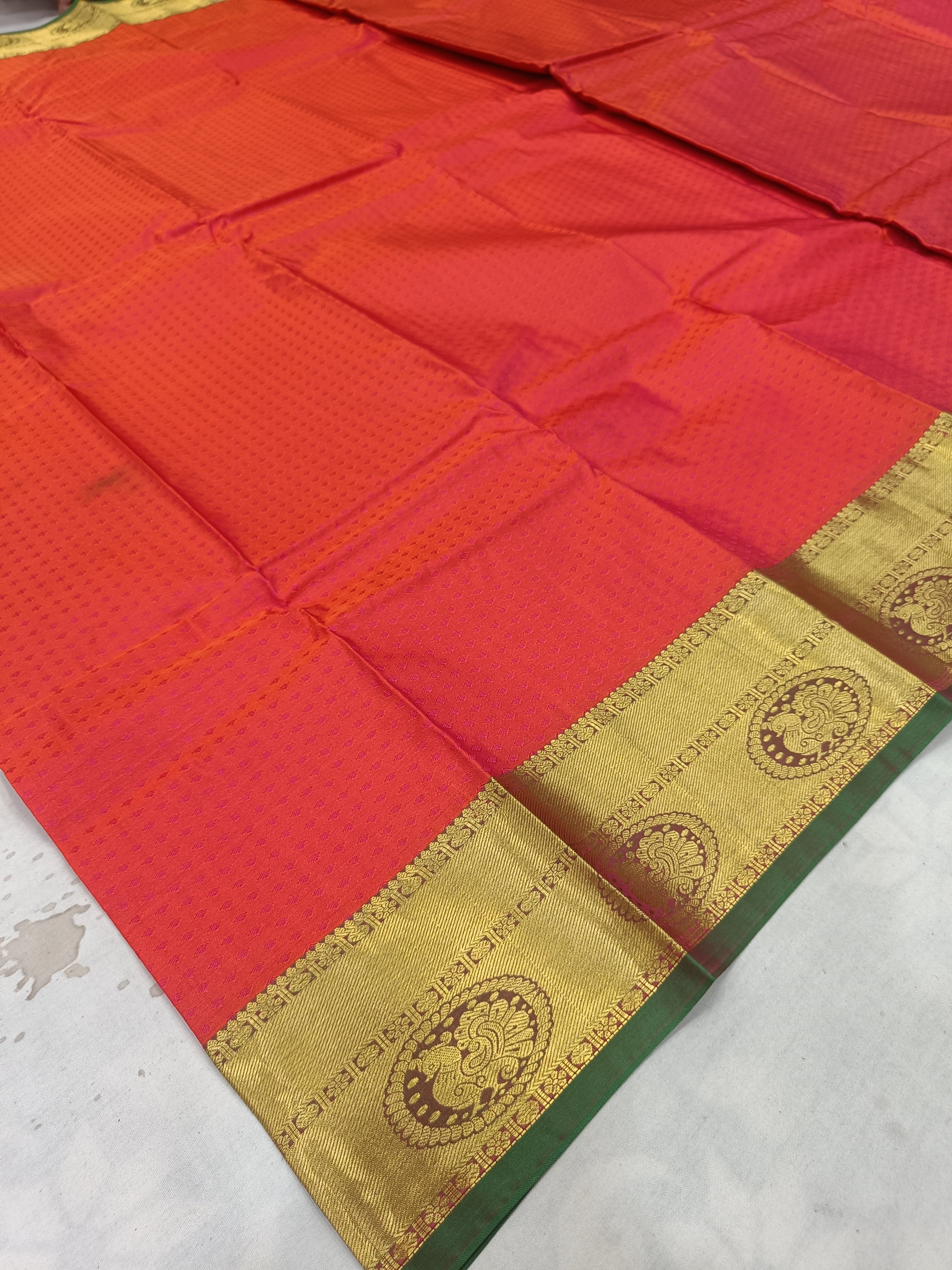 Red silk fabric with gold zari border and ornate circular motifs