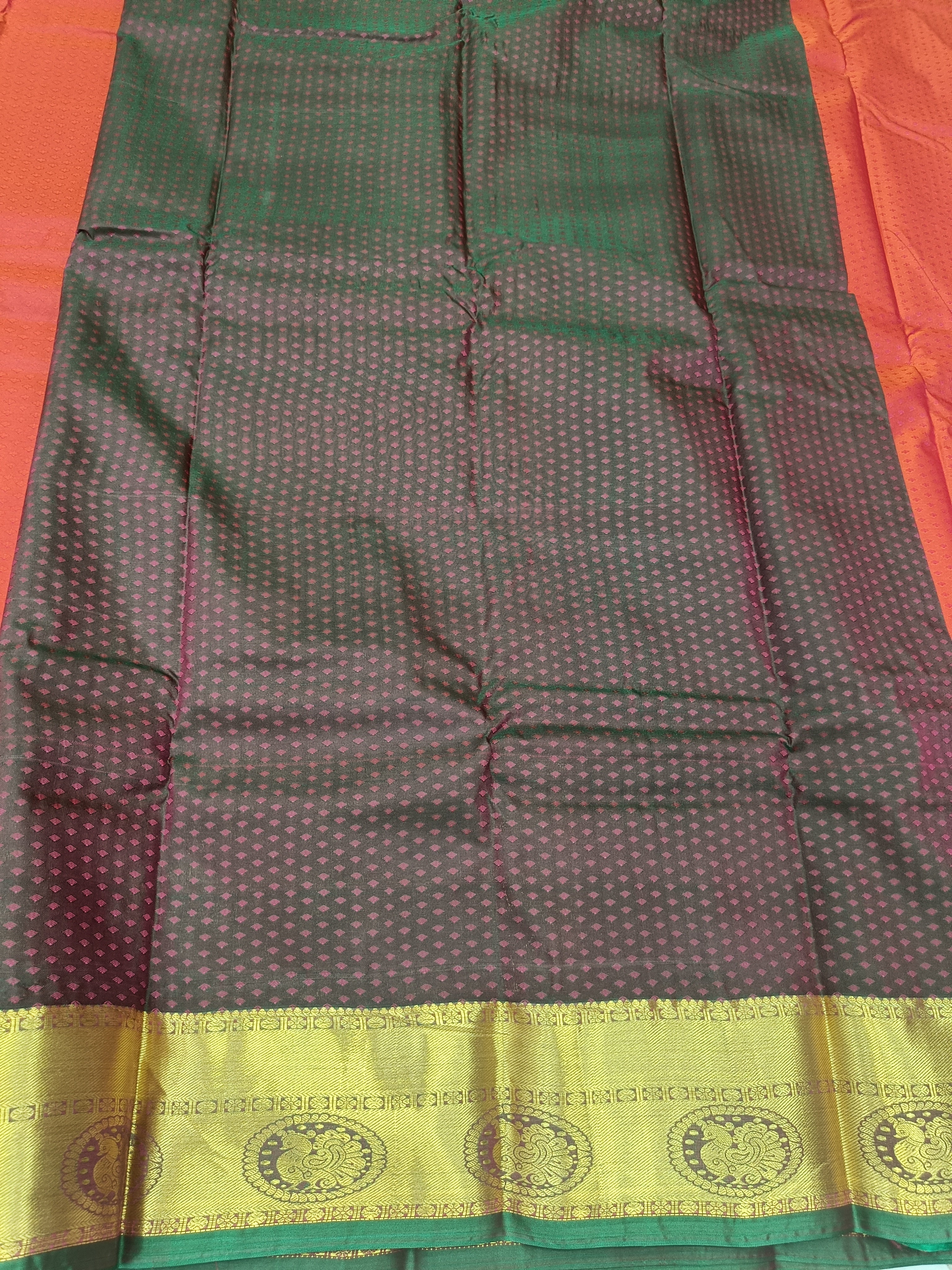 Green and dark maroon patterned saree section with gold border at hem