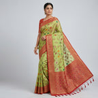Model wearing a light green and maroon silk saree with red-toned pallu border