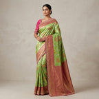 Light green and pink silk saree worn by model, gold border and woven pallu